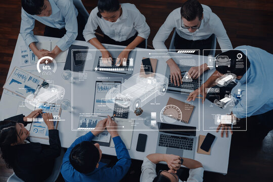 A diverse group of professionals collaborate around a modern office table, using laptops and discussing data analytics while digital graphics enhance the atmosphere. Trope - Powered by Adobe