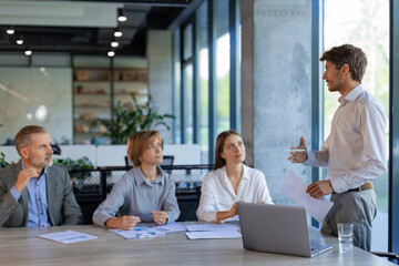 Professional executive businesspeople discuss corporation project planning sit at meeting room, brainstorm financial plan working together in office