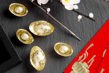Golden Ingots and Red Envelopes on Dark Background for Lunar New Year