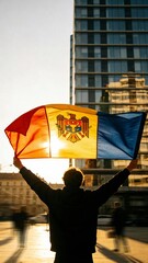 A person proudly displays the Moldovan flag against a stunning cityscape at sunset, ideal for cultural events or urban lifestyle imagery.