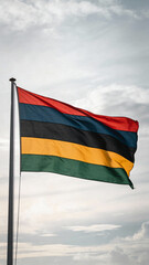 A flag with horizontal stripes of red, blue, black, yellow, and green waves gently against a cloudy sky, ideal for cultural representations.