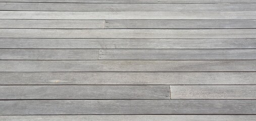 Close-up of weathered grey wooden planks forming a horizontal textured background. Ideal for rustic...