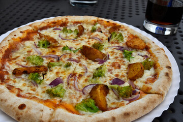 Pizza with broccoli and potatoes on a plate