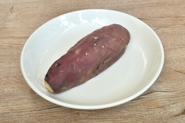 grilled Japanese purple yam with peel arranging on plate 