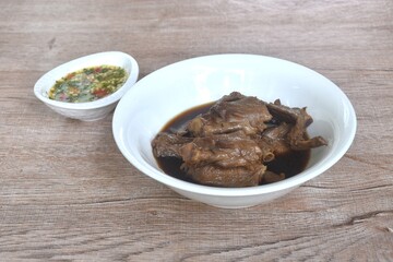 chop boiled duck wing stew in brown soy soup on bowl dipping spicy sour chili sauce 