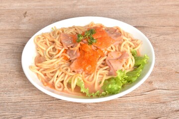 spicy stir fried spaghetti with slice ham pork dressing Rose Korean sauce topping shrimp egg on plate 