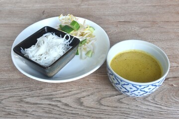 rice noodles on plate with spicy crab curry sauce in bowl eat couple fresh vegetable