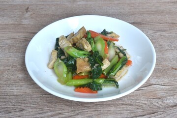 fried Kailaan Chinese kale and carrot with tofu dressing soy sauce vegetarian food on plate