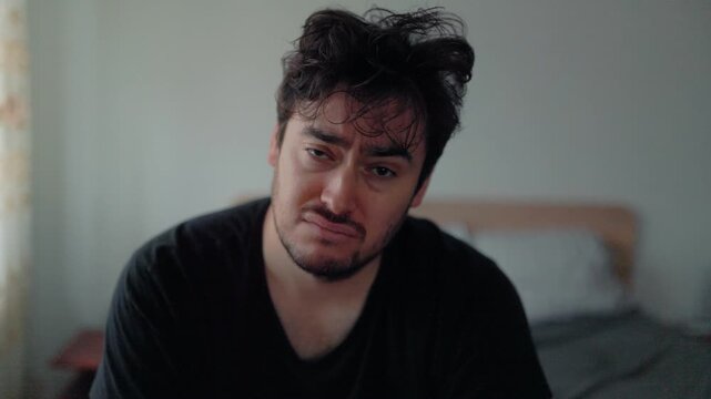 Morning fatigue expression of tired man sitting in bedroom