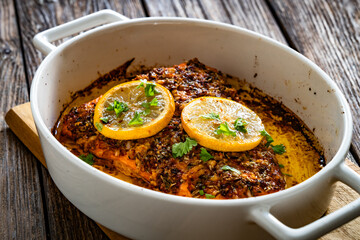 Baked salmon fillet on wooden table	
