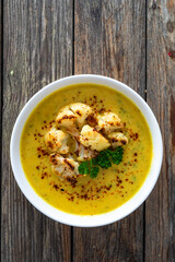 Cauliflower cream soup on wooden table. Top view