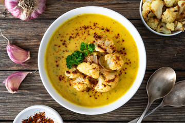 Cauliflower cream soup on wooden table. Top view