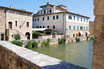 Obraz premium L'antica vasca termale, nota come Piazza delle Sorgenti, nel cuore di Bagno Vignoni in Val d'Orcia in provincia di Siena, Toscana, Italia.