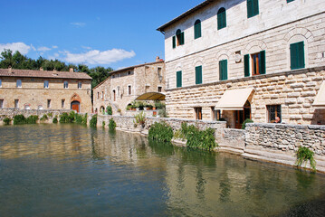 Obraz premium L'antica vasca termale, nota come Piazza delle Sorgenti, nel cuore di Bagno Vignoni in Val d'Orcia in provincia di Siena, Toscana, Italia.