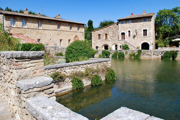 Obraz premium L'antica vasca termale, nota come Piazza delle Sorgenti, nel cuore di Bagno Vignoni in Val d'Orcia in provincia di Siena, Toscana, Italia.