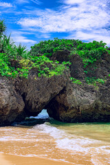  波が寄せる岩の間から青い海を望む石垣島の美しい風景