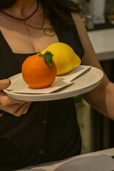 Person Holding Plate with Orange Shaped and Lemon Shaped Gourmet Desserts