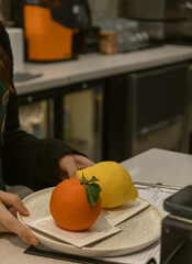 Person Holding Plate with Orange Shaped and Lemon Shaped Gourmet Desserts