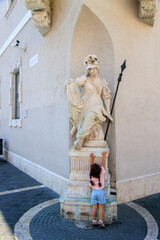 Budapest, Hungary. Stone Pallas Athena statue at the corner of a house in the Holy Trinity Square.