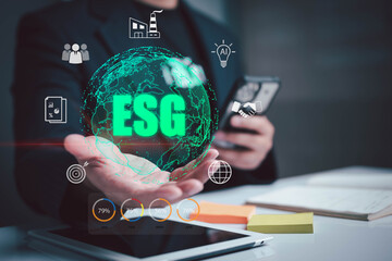Businessman holding digital ESG globe with environmental, social, and governance icons. Concept of sustainable business strategy, ethical investment, green technology, and corporate responsibility.