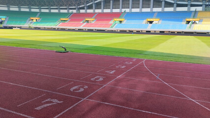 A clean view of an outdoor running track with numbered lanes, bright turf, and clear lane markings. Perfect for themes of athletics, competition, training, and sports performance.