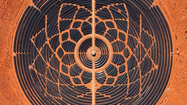 An expansive aerial view of a concentrated solar power plant in a vast desert landscape