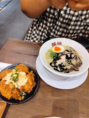 A delicious spread of Japanese ramen featuring spicy red broth, creamy tonkotsu ramen with egg, and crispy fried chicken. A warm, flavorful meal perfect for food lovers and Asian cuisine themes.