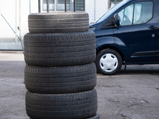 Pile of tires with van in the background, Seasonal tire replacement