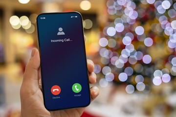 man hand hold phone with incoming call on screen Christmas