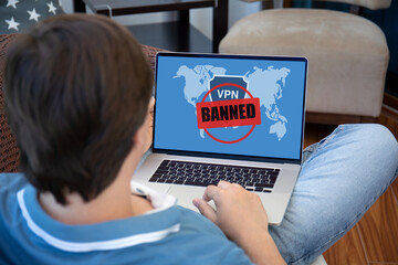 male hands on laptop keyboard with VPN banned on screen