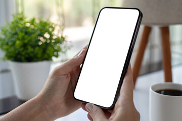 Female hand holding phone with isolated screen over table cafe
