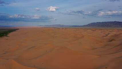 Aerial view of sand dunes in desert at sunset