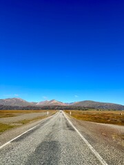 Iceland Ring Road Drive with Endless Straight Highways and Vast Natural Landscapes Beneath a Clear Blue Sky