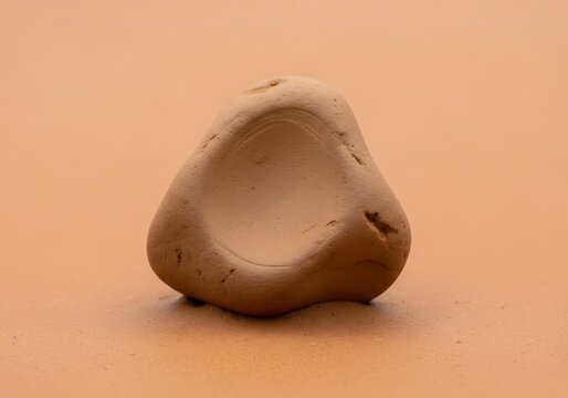 Smooth earthen hued stone with an unique indent resting serenely