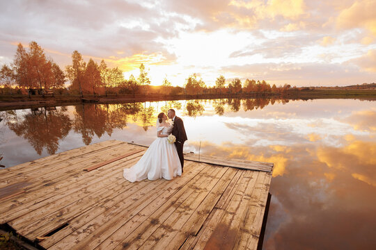 Couple shares a romantic moment at sunset by the serene lake in autumn - Powered by Adobe