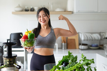A young woman holds various vegetables to make vegetable juice, with a smiling face.