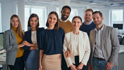 Group portrait of a diverse team in an office setting, smiling and looking at the camera. Their confidence and unity symbolize collaboration and success Stock video