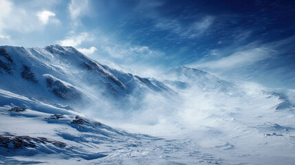 The snow-covered mountain range is swept by strong, icy winds under a bright blue sky with wispy clouds, creating a stunning and dramatic winter landscape.