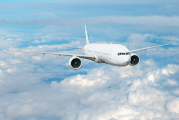 Fototapeta premium White passenger airplane flying in the sky amazing clouds in the background - Travel by air transport