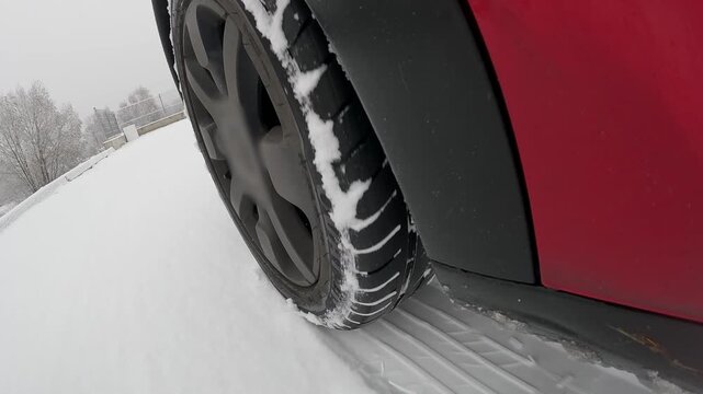 Car wheel sliding on snow during winter driving with ABS braking action
