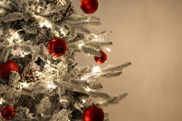 Beautiful snow-dusted Christmas tree with glowing lights and red ornaments, perfect for themes of warmth, celebration, and holiday charm.