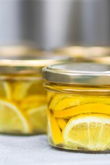 Jars filled with vibrant lemon slices preserved in syrup, showcasing a colorful arrangement of citrus fruits, emphasizing freshness and culinary creativity in food preservation