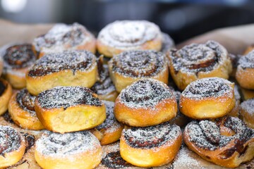 Freshly baked cinnamon rolls dusted with powdered sugar, arranged on a wooden board, showcasing a delicious dessert perfect for breakfast or special occasions
