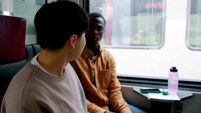  two young men friends talking traveling in the train 