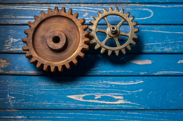 Vintage gear wheels arranged on aged wood surface with metallic highlights