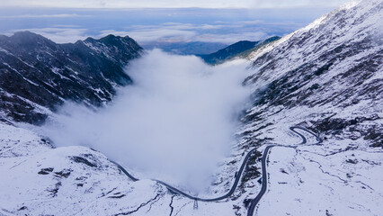 Aerial photography of a winding road in the mountains with serpentines and curves. Photography of transfagarasan road in Sibiu county, Romania. Photo was shot from a drone at a higher altitude.