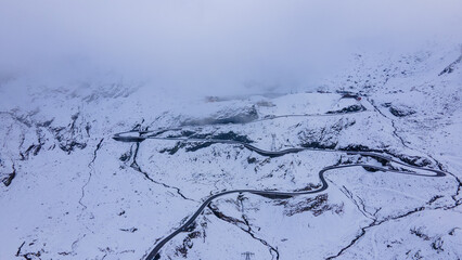 Aerial photography of a winding road in the mountains with serpentines and curves. Photography of transfagarasan road in Sibiu county, Romania. Photo was shot from a drone at a higher altitude.