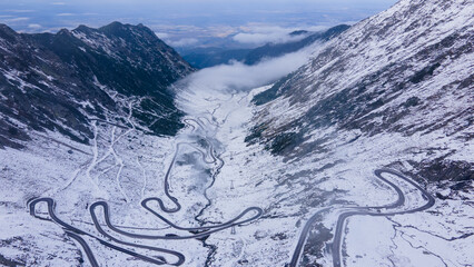 Aerial photography of a winding road in the mountains with serpentines and curves. Photography of transfagarasan road in Sibiu county, Romania. Photo was shot from a drone at a higher altitude.