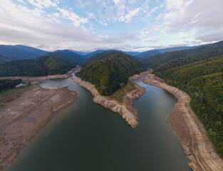 Wide angle photography of Lake Vidraru in Romania taken from a drone. Photography was shot from a higher altitude, and it can be seen the dried lake bed.