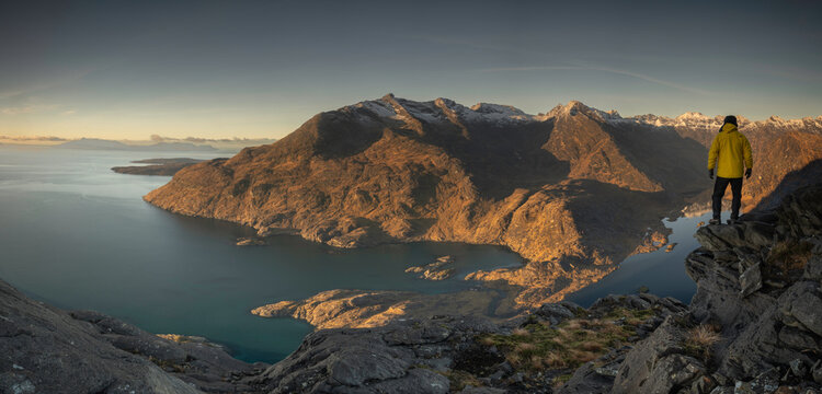 panoramic image of hiker looking towards the Black Cuillin mountains, located on the Isle of Skye, Scotland. - Powered by Adobe